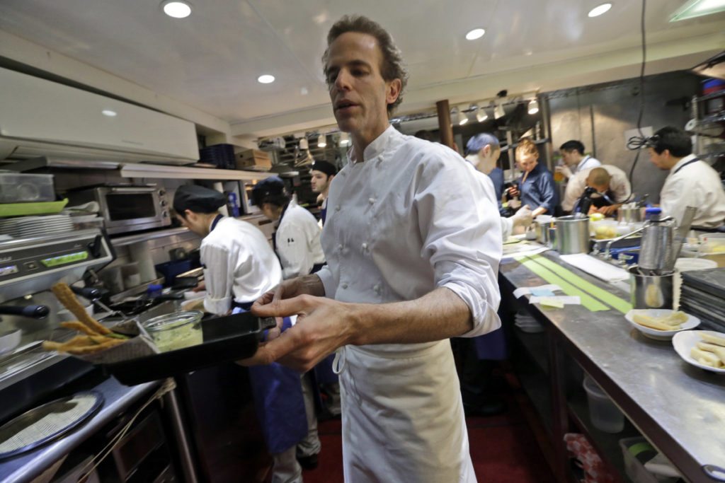 In this Thursday, March 19, 2015 photo, chef Dan Barber hands a waiter an order of fried skate wing cartilage with smoked whitefish head tartar sauce at WastED in New York. Dishes using scraps and other ignored bits comprise the menu at chef Dan Barber